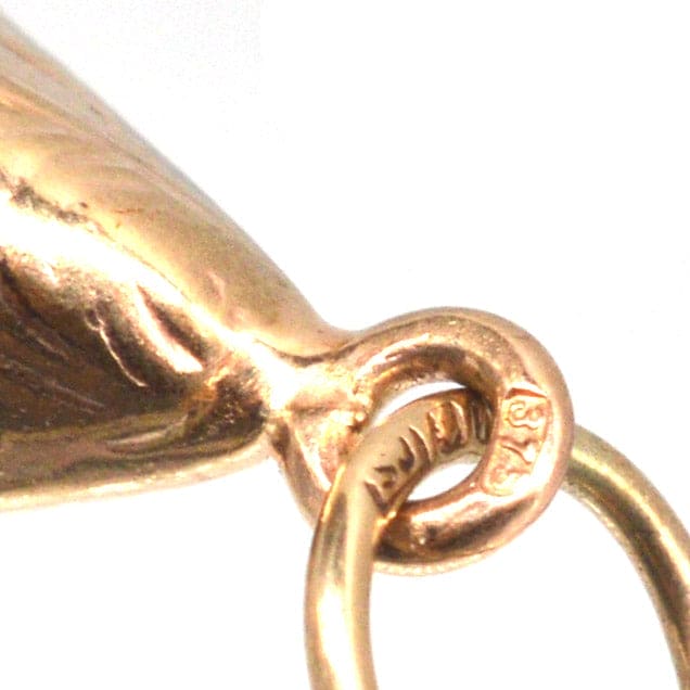 Close-up of a vintage 9ct gold mussel shell charm with hallmark and attachment loop, ideal for charm bracelets or pendants.