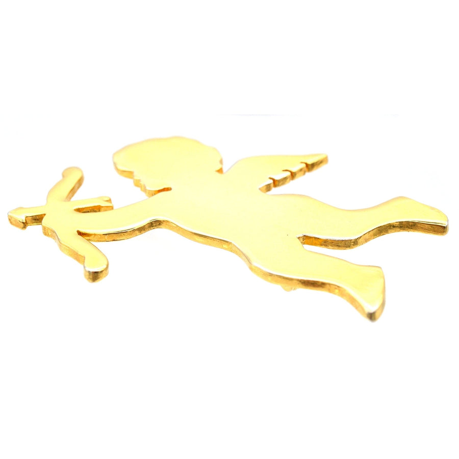 Gold-tone Cupid brooch depicting a cherubic figure holding a bow and arrow.