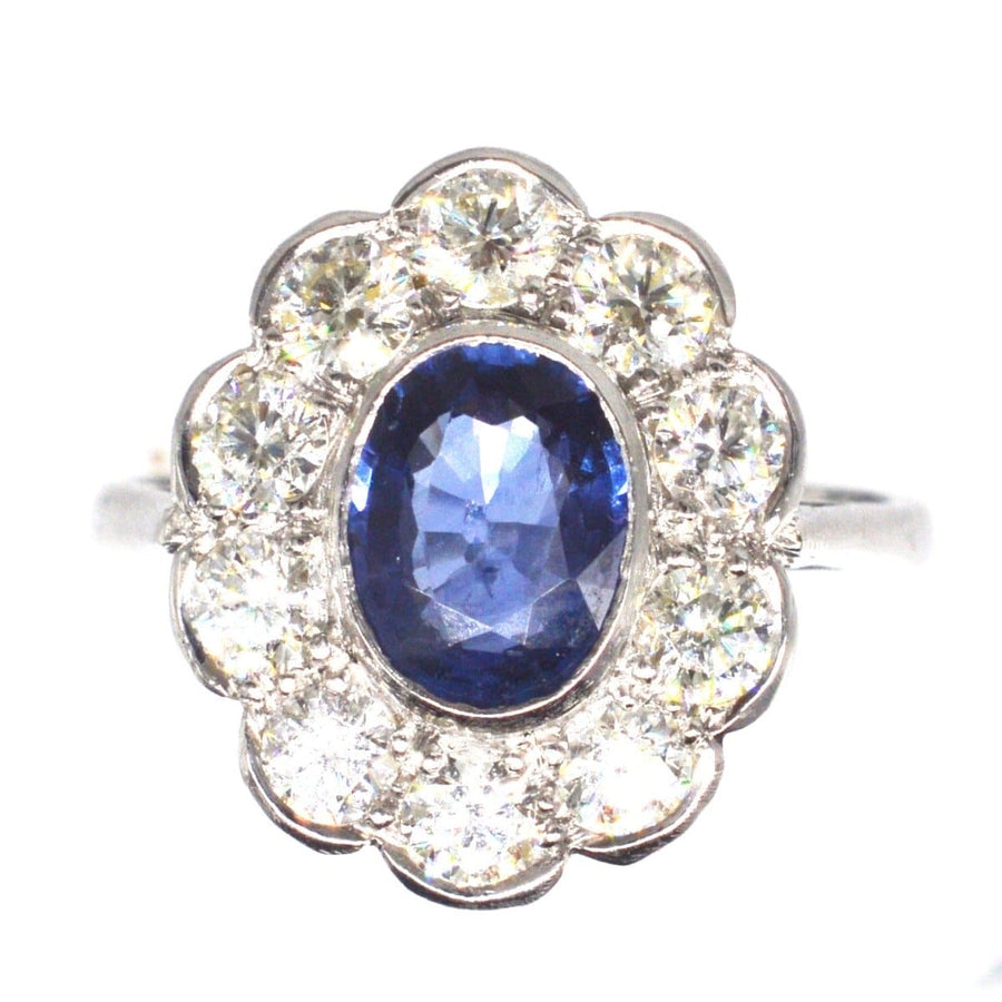 Vintage platinum sapphire and diamond cluster ring featuring 1 carat sapphire and 1.2 carats of diamonds.