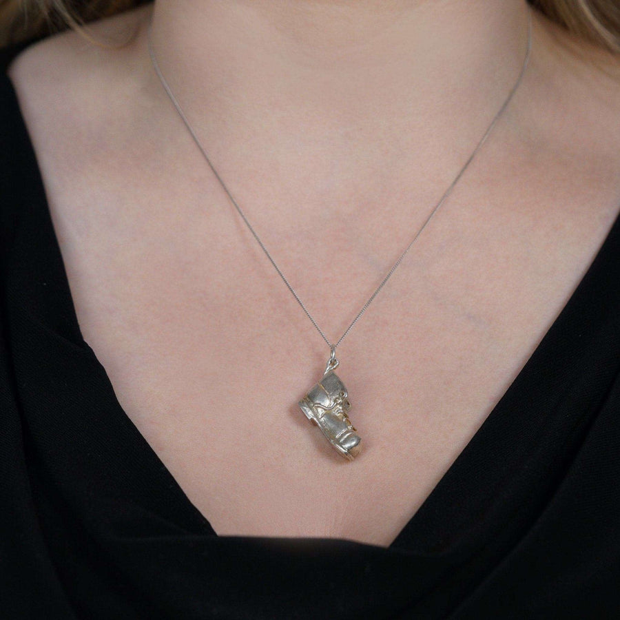 Vintage silver boot pendant charm on a necklace, showcasing its 1970s design.