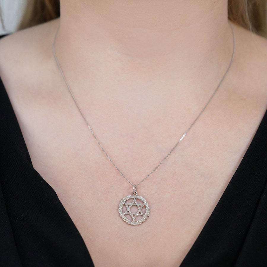 Silver Star of David pendant on a delicate chain, symbolizing Judaism and adorned with a laurel wreath.