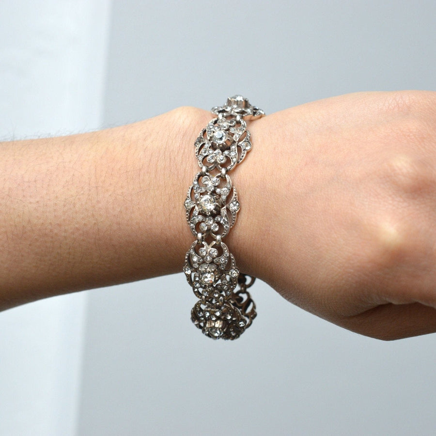 Wide Edwardian silver paste bracelet featuring large foliage-like plaques and sparkling central stone, elegantly worn on a wrist.