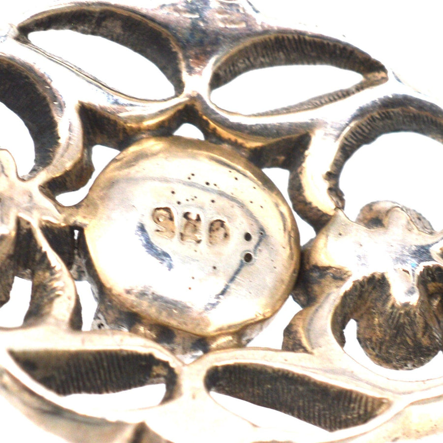 Close-up of the hallmark on a wide Edwardian silver paste bracelet with intricate foliage design.